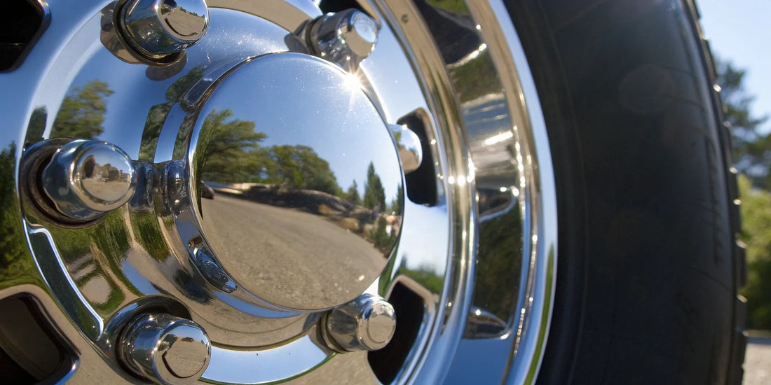 An aluminum wheel polished to a perfect mirror finish, reflecting its surroundings.