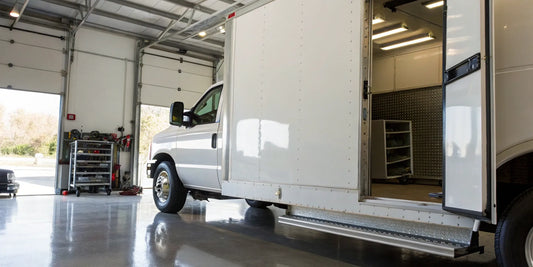 Box truck with an open lift gate in a garage undergoing essential maintenance.