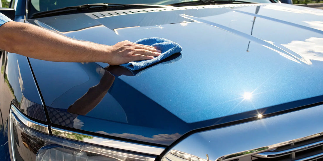Hand polishing a blue truck hood with a microfiber towel during a 1 step paint correction.