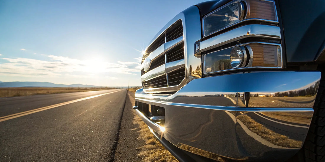 A heavy-duty chrome truck bumper for sale on a pickup driving on an open road.